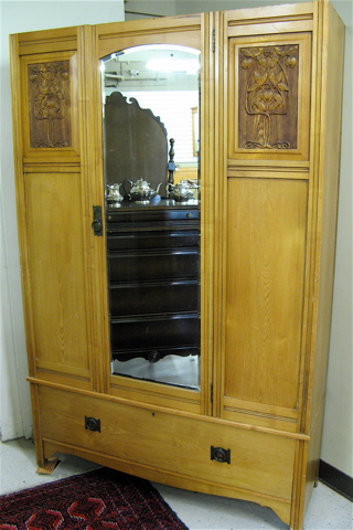 Appraisal: GOLDEN ASH WARDROBE English c centering a mirror panel door