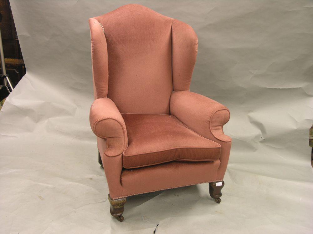 Appraisal: A wing armchair upholstered in a plum dralon on short