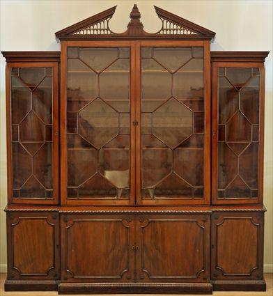 Appraisal: GEORGE III-STYLE MAHOGANY BREAKFRONT BOOKCASE The triangle pediment broken with