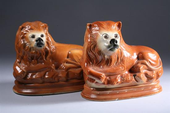 Appraisal: PAIR STAFFORDSHIRE RECUMBENT LIONS late th century With glass eyes