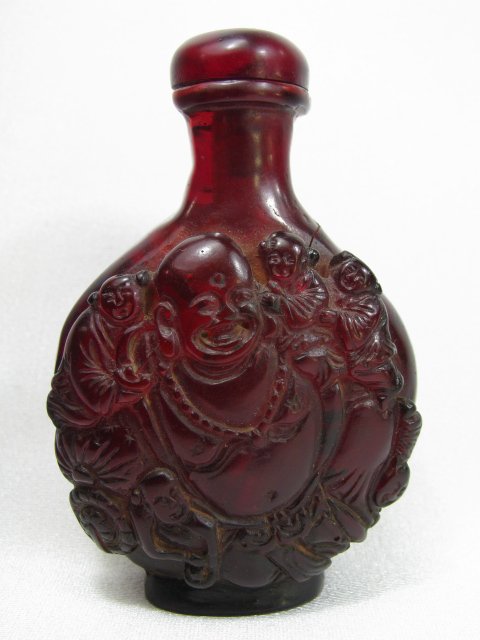 Appraisal: Chinese carved amber color glass snuff bottle with scenes of