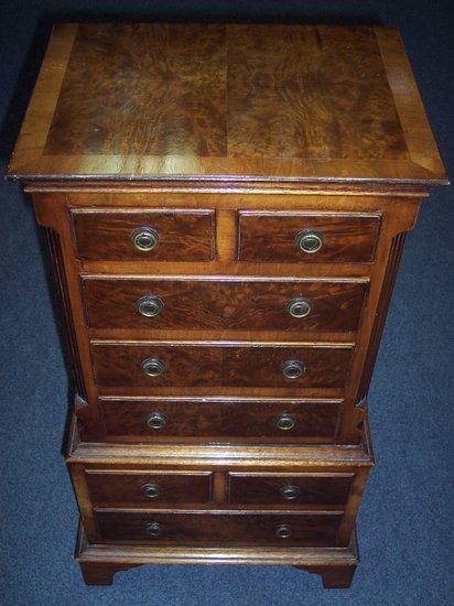 Appraisal: A walnut crossbanded miniature walnut chest fitted four long and