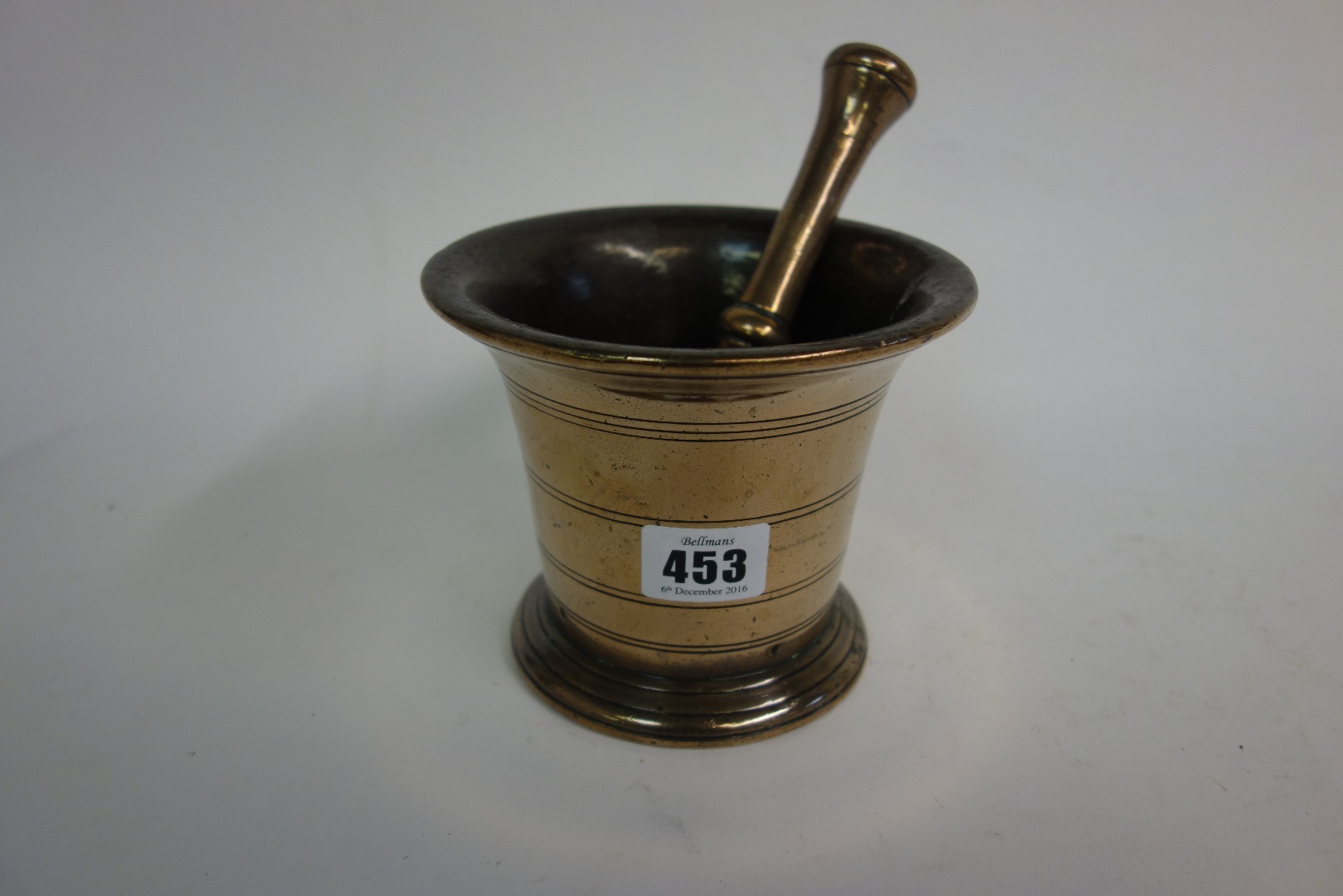 Appraisal: A bell metal pestle and mortar th century the sides