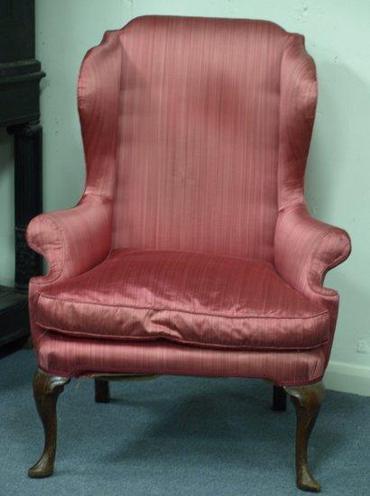 Appraisal: An upholstered wing back armchair of Queen Anne design having