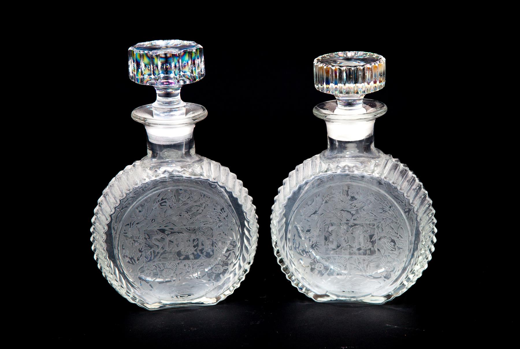 Appraisal: TWO CLEAR GLASS DECANTERS WITH ETCHED DESIGNS American mid th