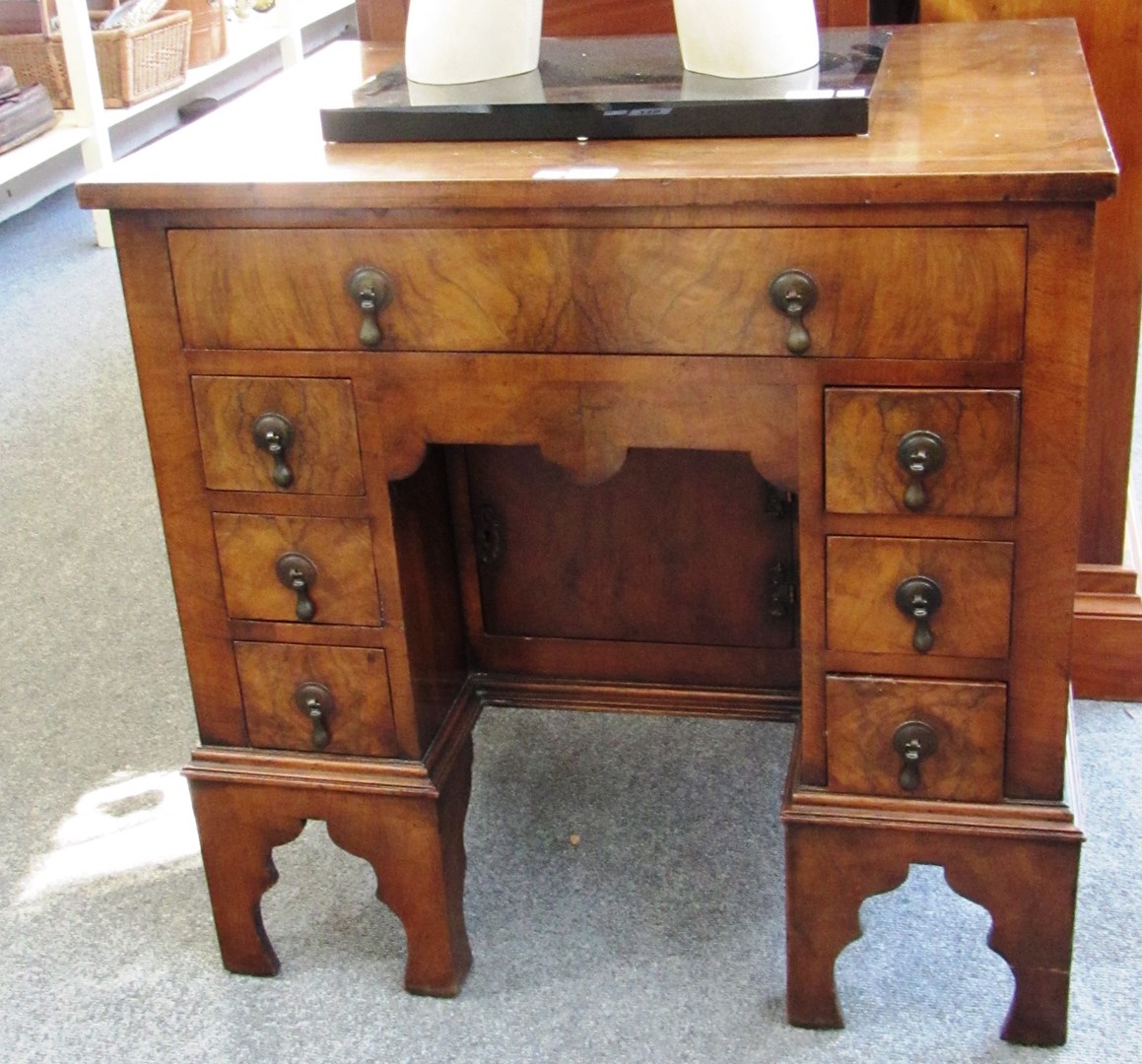 Appraisal: A Queen Anne style walnut kneehole writing desk with seven