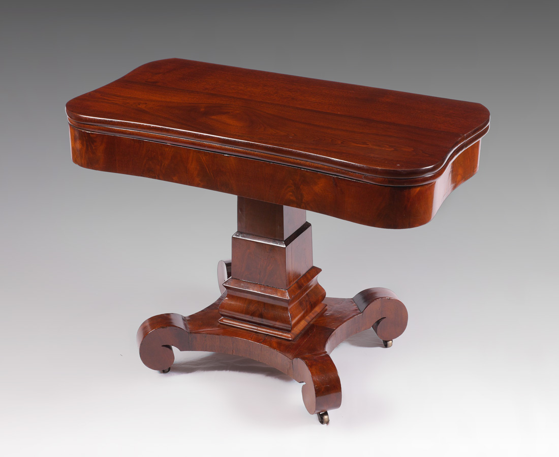 Appraisal: EMPIRE MAHOGANY GAME TABLE Shaped top with rounded corner swivels