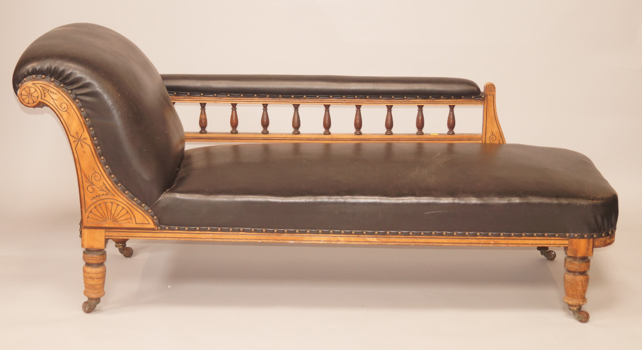 Appraisal: A Victorian walnut chaise longue upholstered in black leatherette on