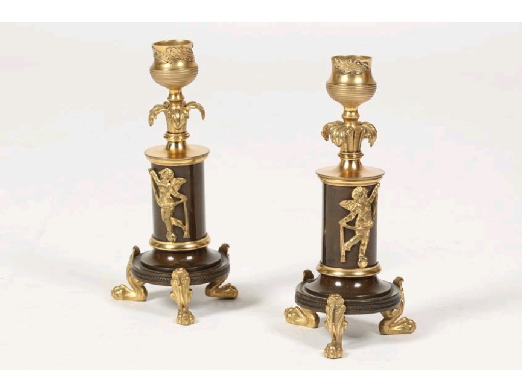 Appraisal: A PAIR OF REGENCY BRONZE AND ORMOLU CANDLESTICKS with leaf-mounted