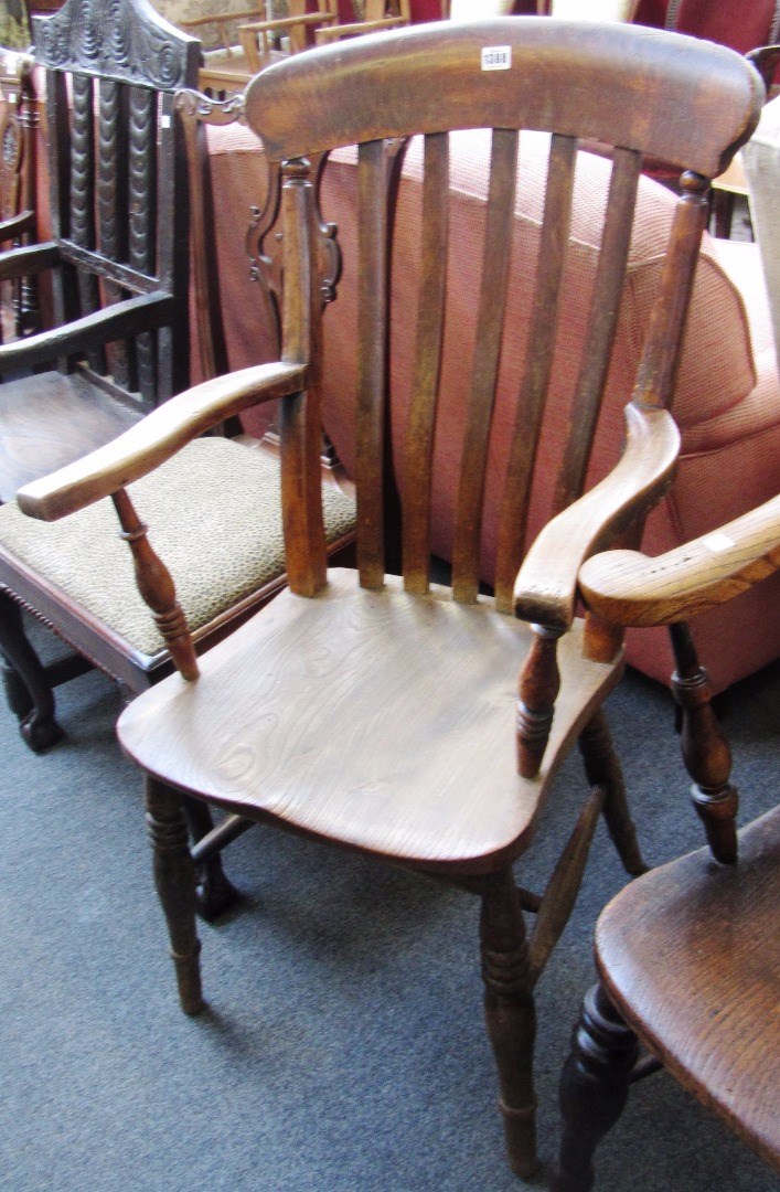 Appraisal: A Victorian beech and elm kitchen Windsor open armchair on