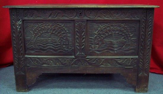 Appraisal: A carved oak chest the plank top above a fall