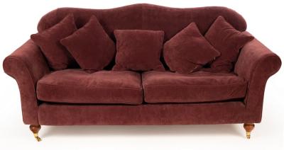 Appraisal: An upholstered sofa covered in mauve material and raised on