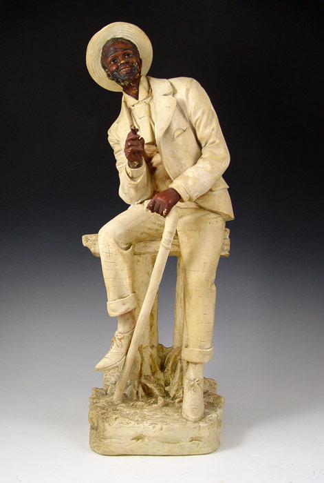 Appraisal: TH CENTURY ''UNCLE TOM'' PLASTER SCULPTURE Man seated with cigar