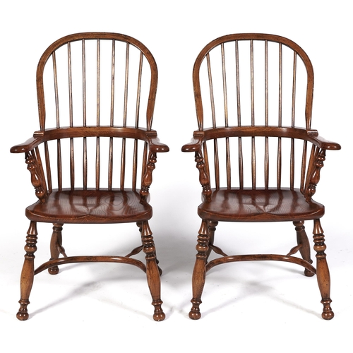 Appraisal: A pair of reproduction elm broad arm highback Windsor elbow