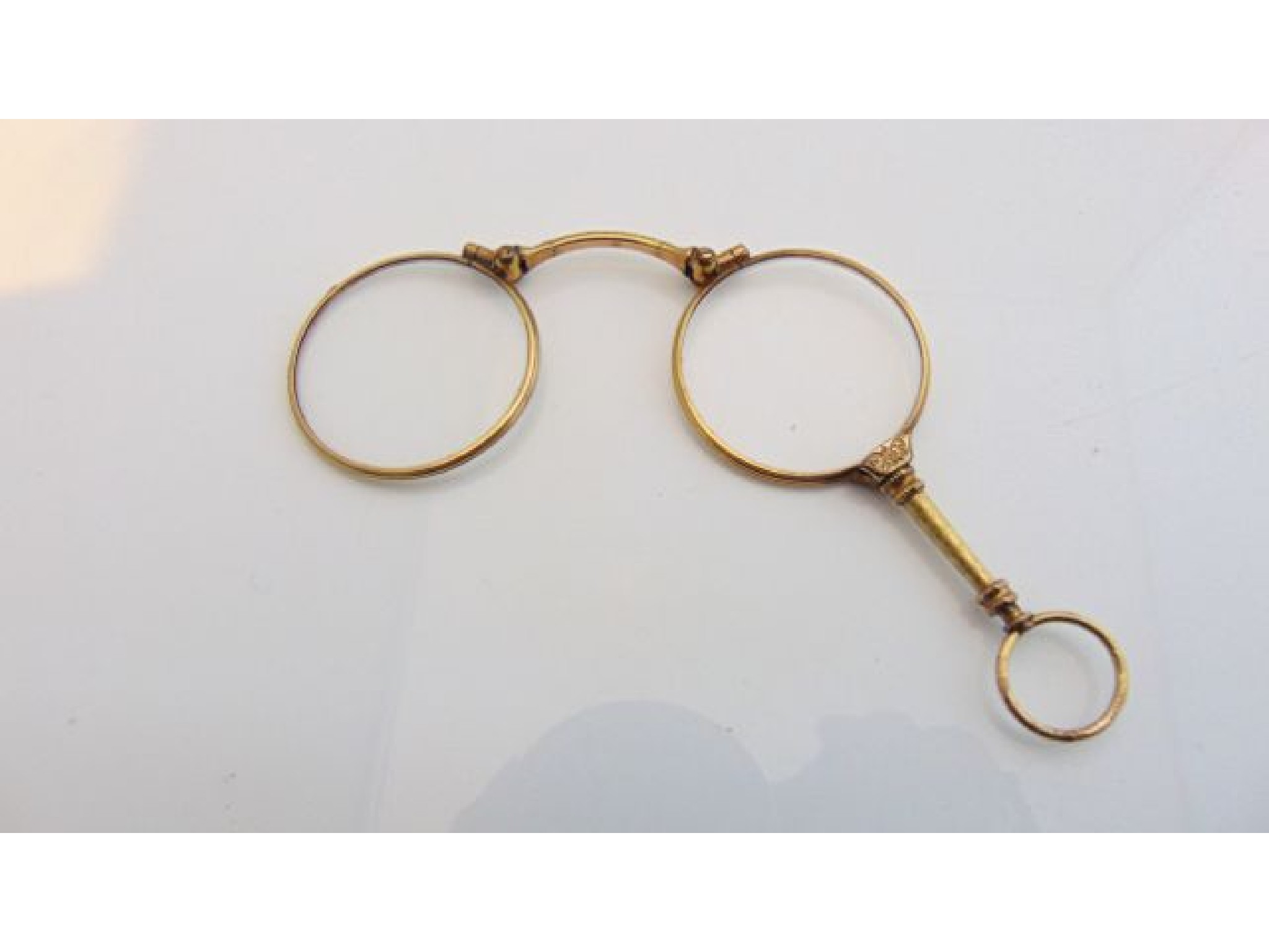 Appraisal: A gold-plated lorgnette with engine-turned and floral details