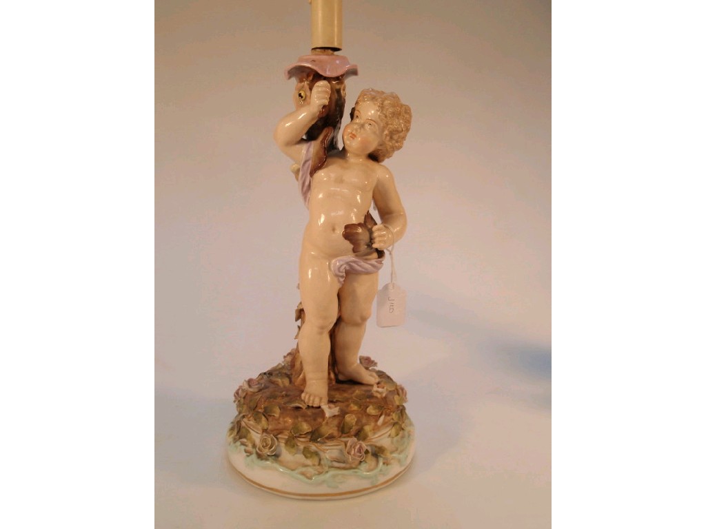 Appraisal: A Thuringia porcelain table lamp modelled as a cherub holding