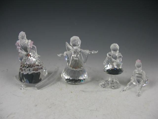 Appraisal: Four Swarovski Crystal Figures one angel one young girl two