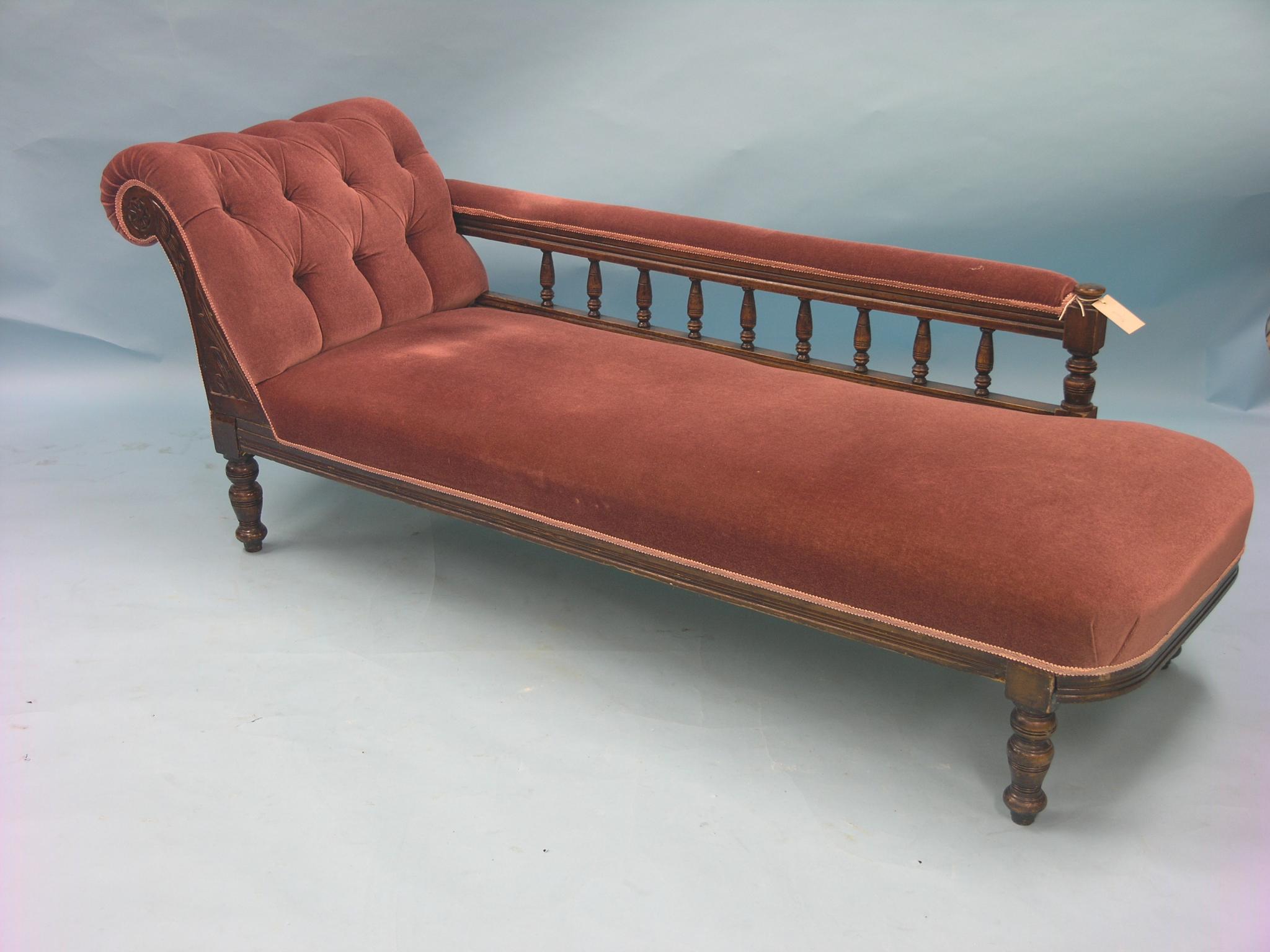 Appraisal: A Victorian chaise longue with turned beech spindle gallery upholstered