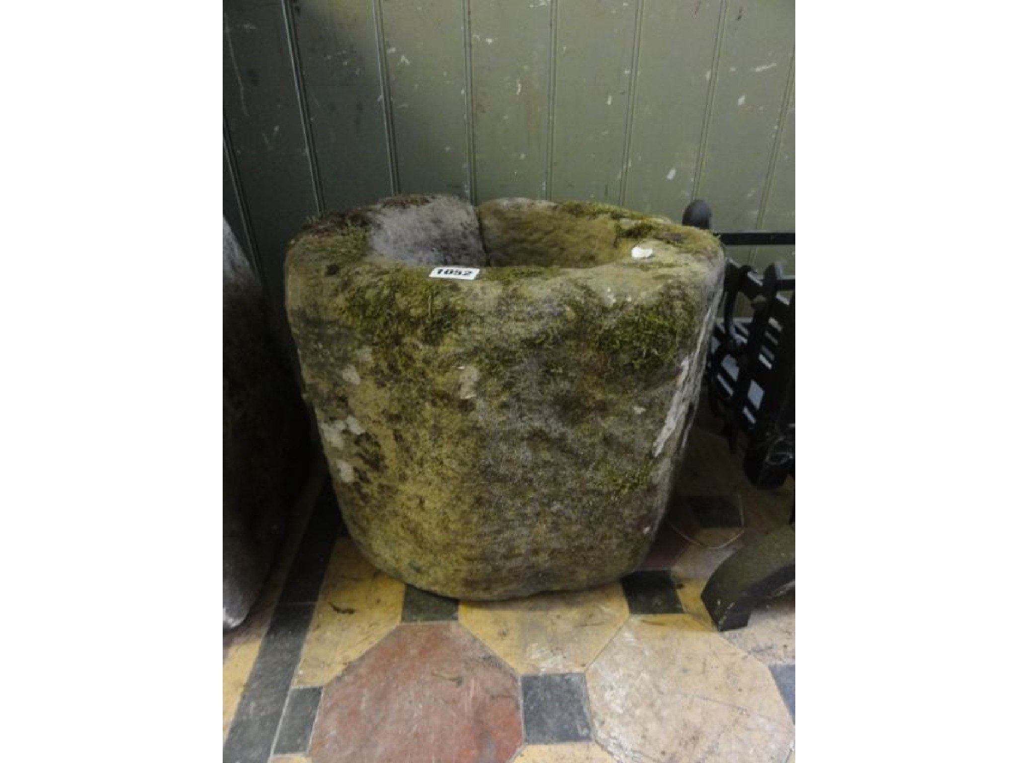 Appraisal: A weathered carved stone quern mortar of octagaonal form