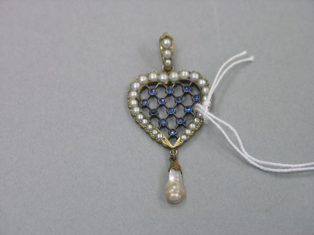 Appraisal: A late Victorian heart shaped pendant set with central blue