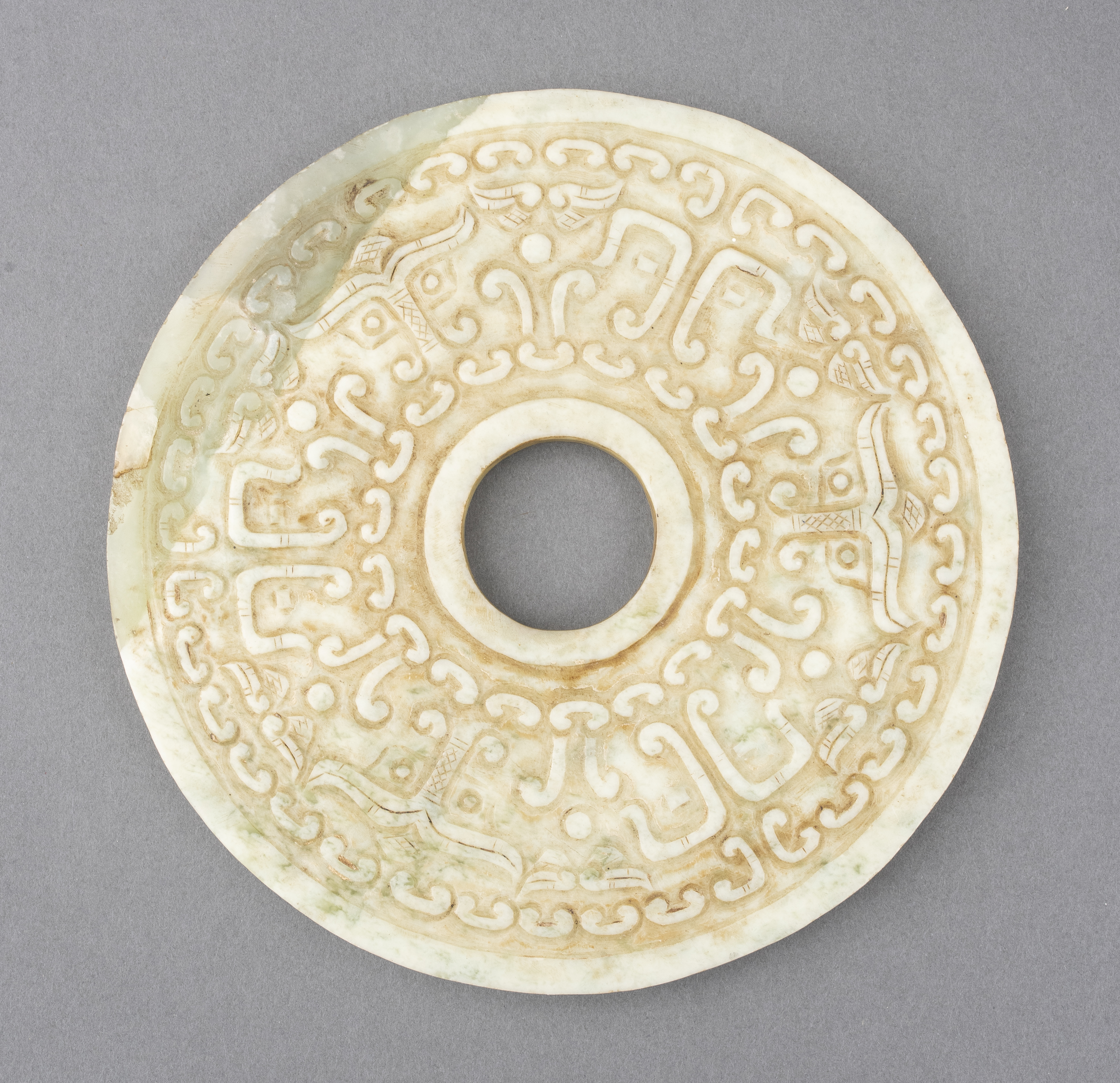 Appraisal: CHINESE ARCHAISTIC HARDSTONE CARVED DISC Chinese green hardstone carving with