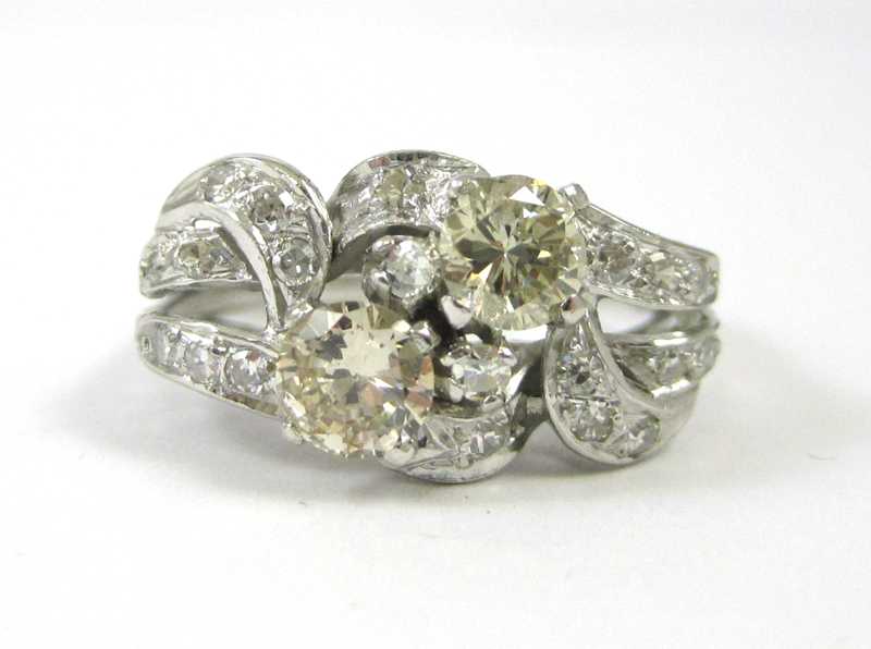 Appraisal: DIAMOND AND PLATINUM RING featuring two round brilliant-cut colored diamonds