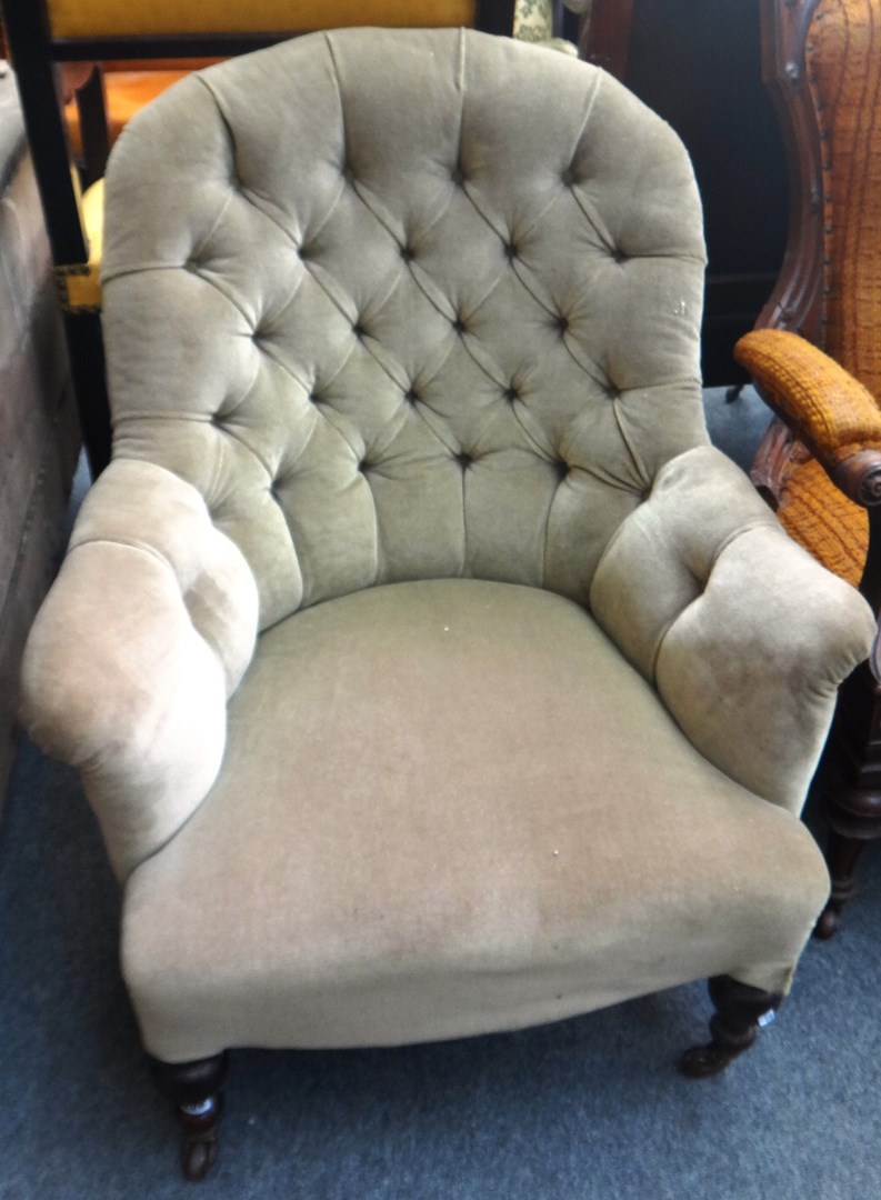 Appraisal: A Victorian button back armchair on turned rosewood supports