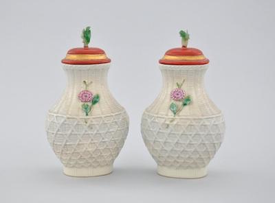 Appraisal: A Pair of Molded Porcelain Vases with Carved Wood Lids