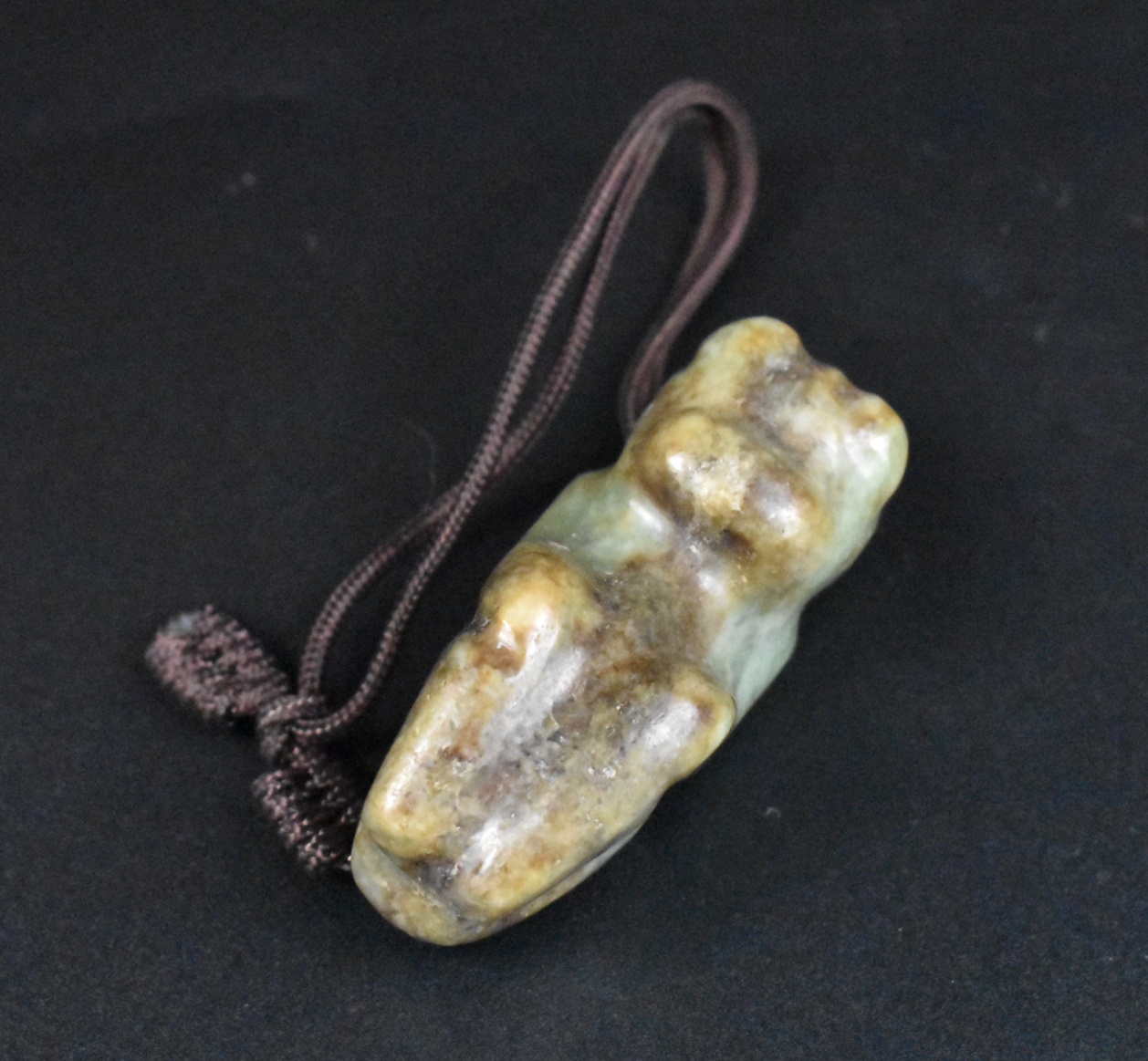 Appraisal: A Chinese jade carved beast cord attached through hole behind