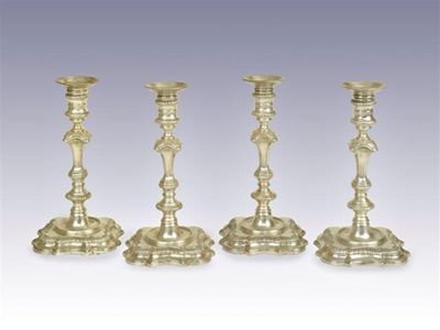 Appraisal: A set of four George II cast candlesticks on shaped