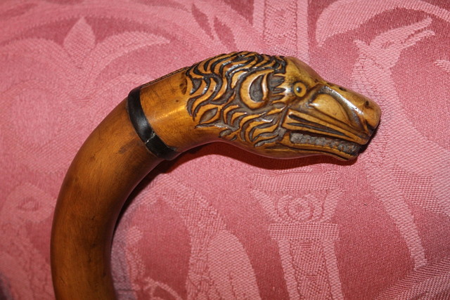 Appraisal: A CARVED WALKING STICK with lion head mount and with