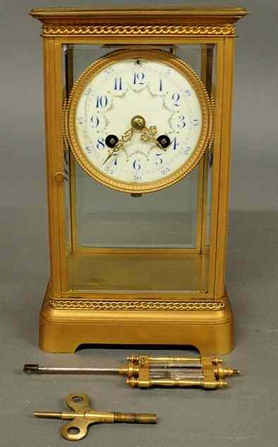 Appraisal: French brass and beveled glass mantel clock with a porcelain