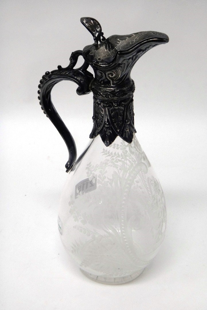 Appraisal: A Victorian silver mounted glass claret jug the body etched