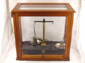 Appraisal: A glazed hardwood case containing a set of scientific balance