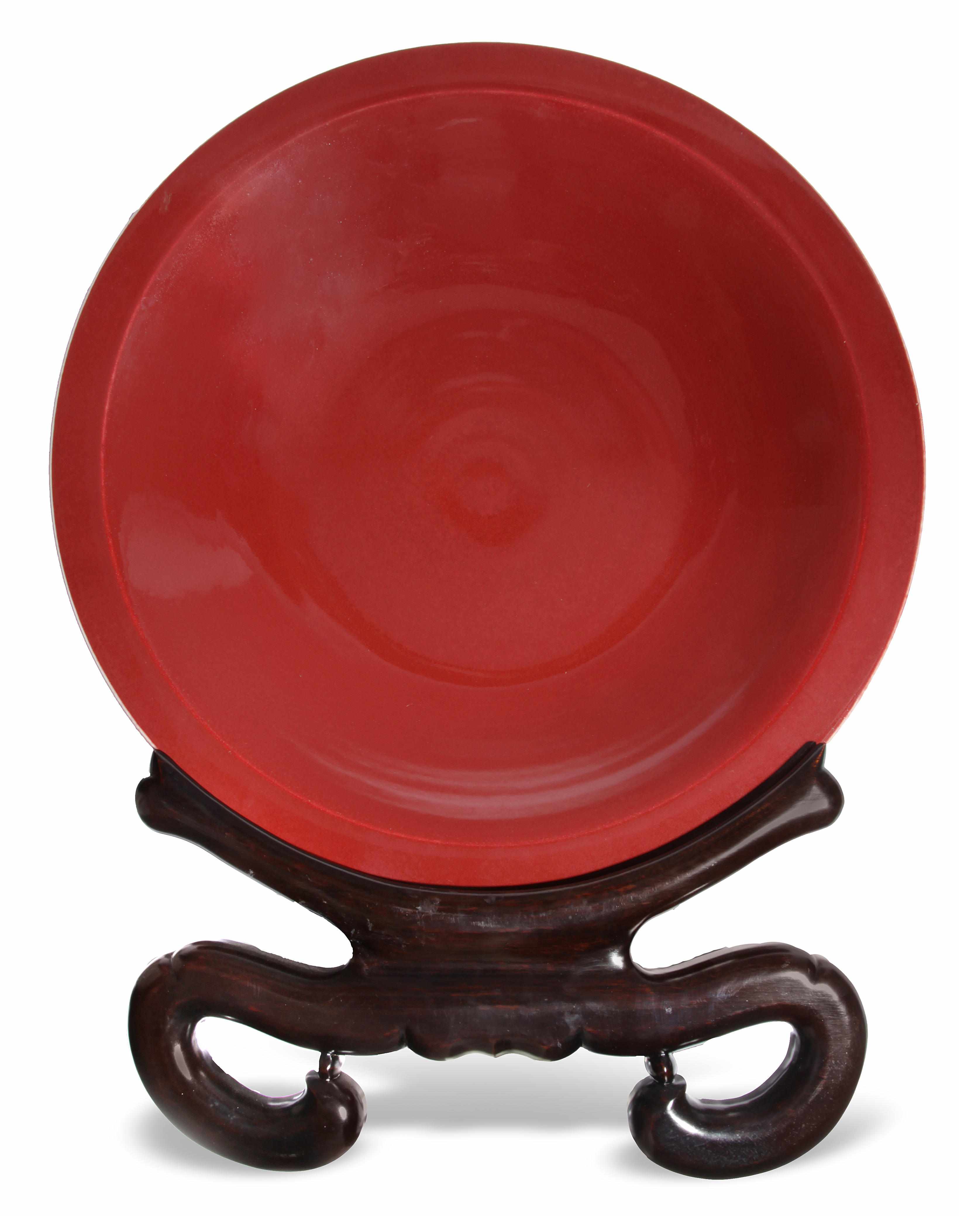 Appraisal: A Chinese sang de boeuf glazed porcelain charger on ebonized