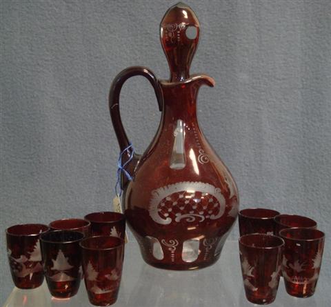 Appraisal: pc etched ruby flashed Bohemian liquer set handled decanter h