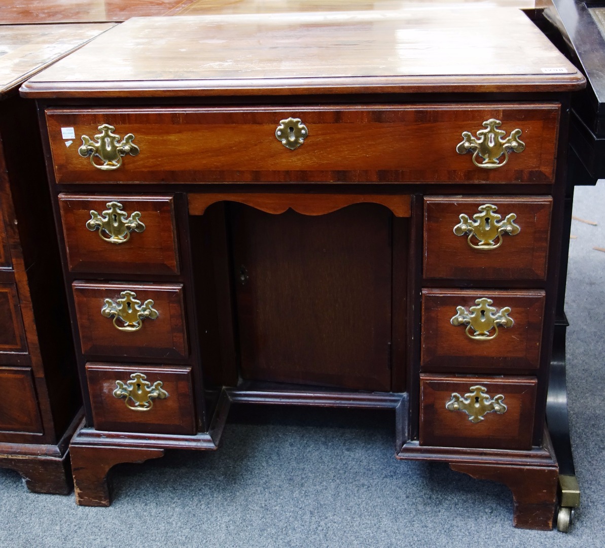 Appraisal: An th century mahogany kneehole writing desk with seven drawers