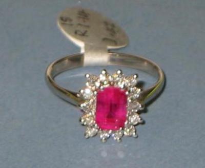 Appraisal: A RUBY AND DIAMOND CLUSTER RING comprising emerald cut ruby