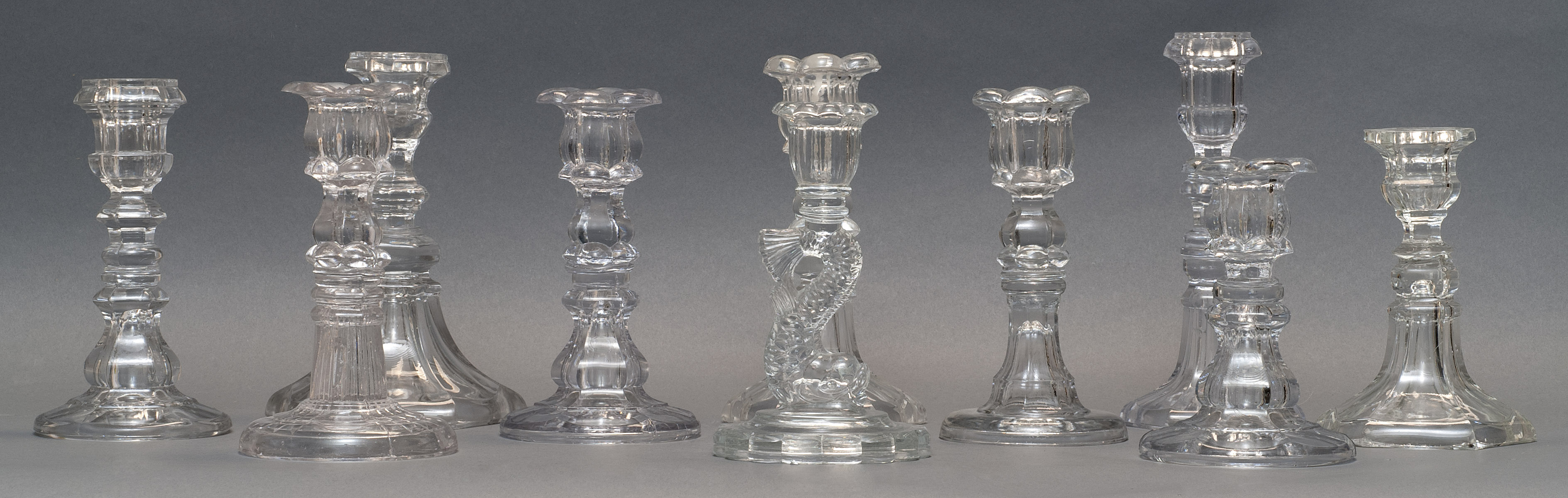 Appraisal: TEN ASSORTED CLEAR PRESSED GLASS CANDLESTICKS th CenturyIn varied forms