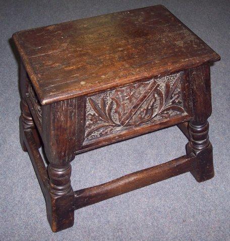 Appraisal: An oak box stool the hinged lid above a carved