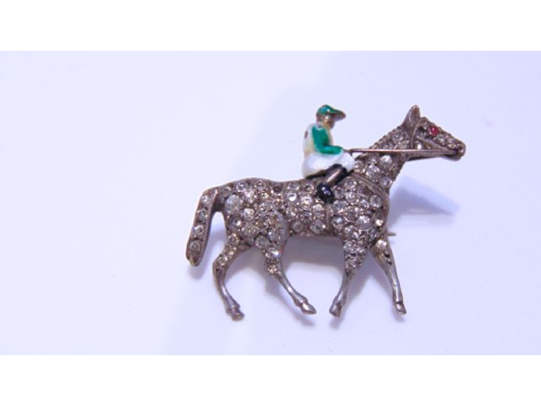 Appraisal: An enamel and paste horse and jockey brooch the horse