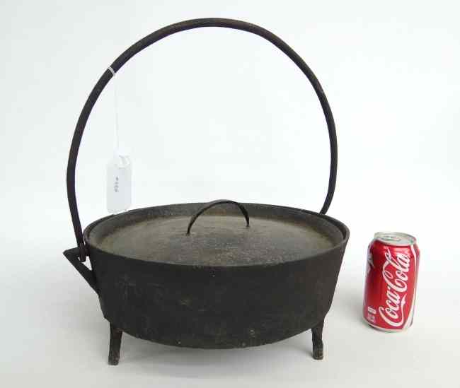 Appraisal: th c cast iron swing handle Dutch oven '' Diameter