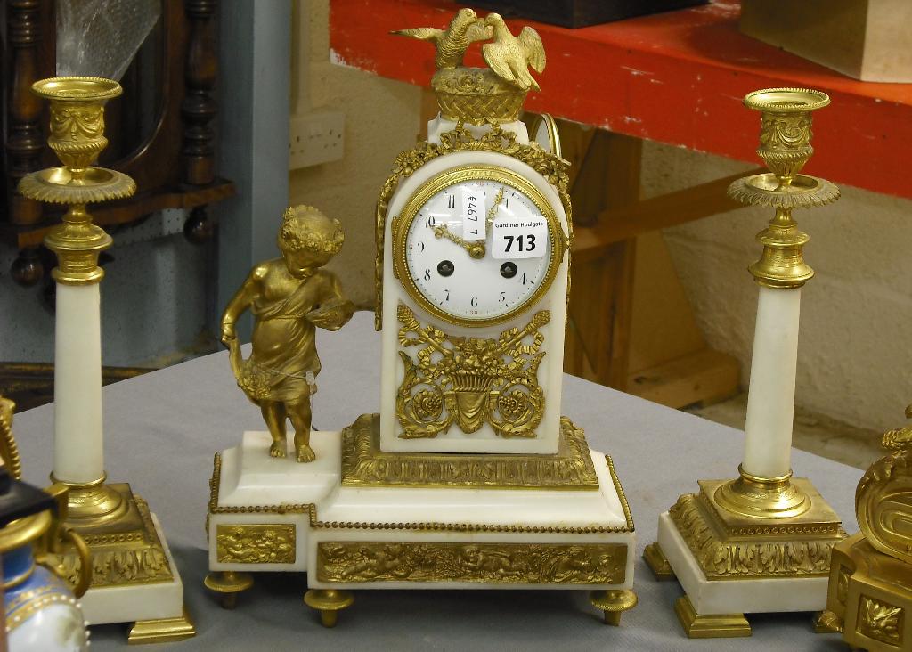 Appraisal: French white onyx and ormolu two train clock garniture the