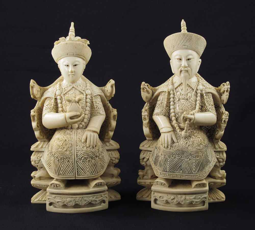 Appraisal: PIECE CARVED IVORY SEATED ROYAL COUPLE Profusely carved Emperor and