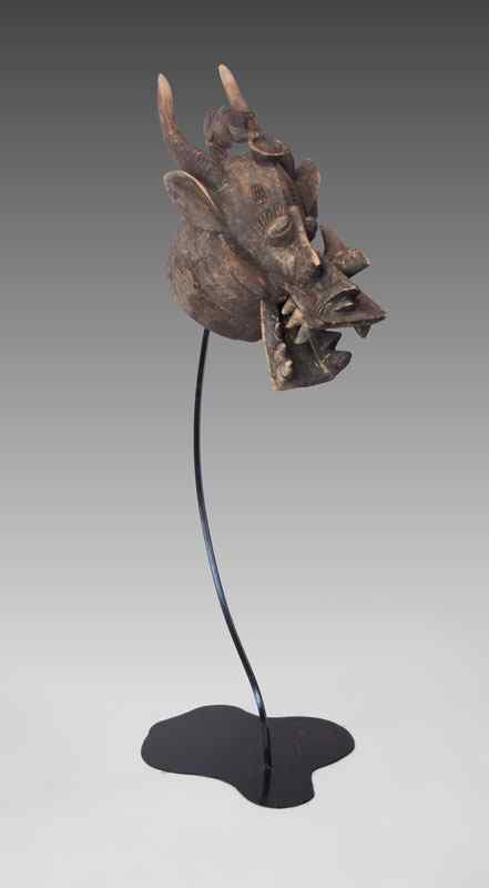 Appraisal: SENUFO AFRICAN CARVED MASK REPRESENTING THE FIRE SPITTER Iron display