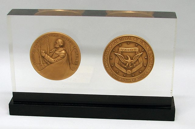 Appraisal: Lucite presentation plaque featuring two imbedded bronze medals Plaque presented