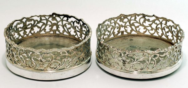 Appraisal: A pair of silverplated wine coasters Engraved and reticulated scroll