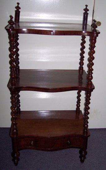 Appraisal: A Victorian rosewood what-not with three serpentine front tiers the