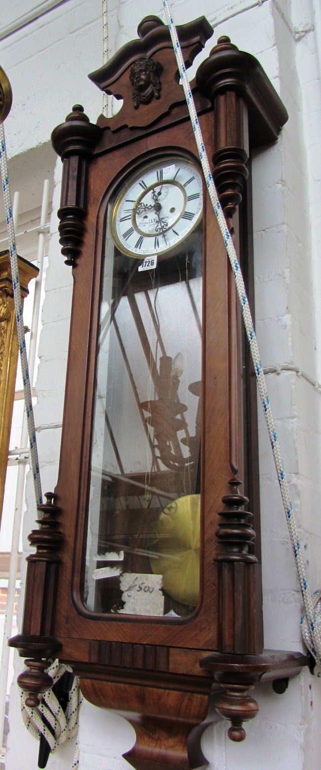 Appraisal: A walnut cased Vienna wall clock with three turned finials