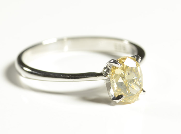 Appraisal: FANCY ORANGE-YELLOW DIAMOND SOLITAIRE RING featuring an oval-cut fancy orange